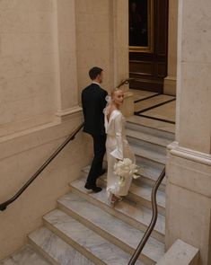 the bride and groom are walking down the stairs