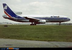 an air tatraa airplane on the runway at an airport in england, with grass and buildings in the background