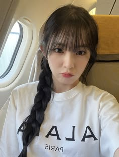 a woman with long hair sitting on an airplane