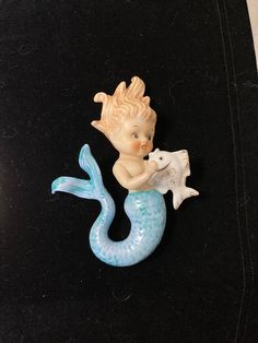 there is a figurine of a little mermaid and a fish