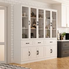 an empty kitchen with white cabinets and black counter tops, in front of a checkered floor