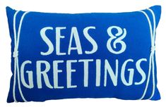 a blue pillow with white lettering that says seas and greetings