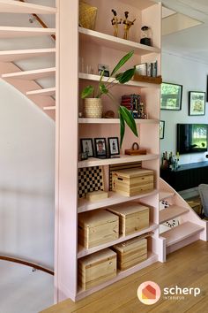 a living room filled with lots of furniture next to a stair case covered in pictures