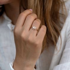 a woman wearing a diamond ring and white shirt