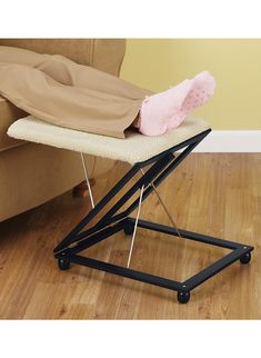 an ironing board with a pink blanket on it and a chair in the background