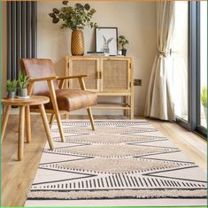 a living room area with a rug, chair and potted plant on the floor