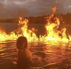 a woman in the water surrounded by fire