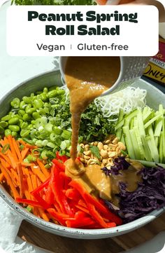 a bowl filled with vegetables and dressing being poured into it to make a vegetable salad