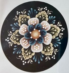 a black and white plate with flowers painted on it's side, in the shape of a flower