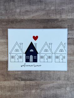 a card with houses and a red heart on it that says, my home is in the middle