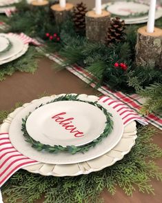 a table set for christmas with plates and candles