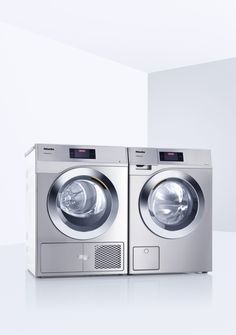 two silver washing machines sitting side by side