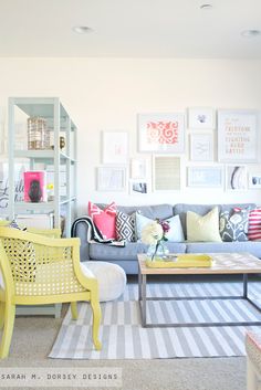 a living room filled with lots of furniture and pictures on the wall above it's coffee table