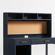 an office desk with a cork board on the top and two drawers below, against a white background