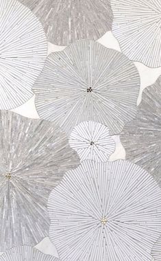 several white umbrellas are hanging from the ceiling in front of a wallpapered background