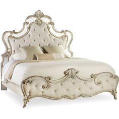 a white bed with an ornate headboard and foot board