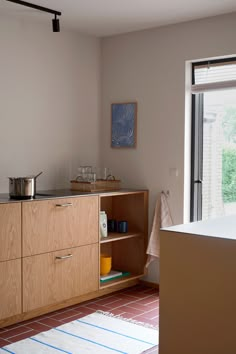 a kitchen area with wooden cabinets and an open door leading to a patio outside the window