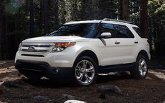 a white ford explorer is parked in the woods