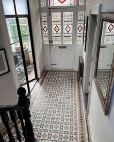 an entryway with stained glass windows and tiled floors