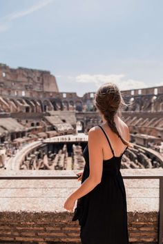 a woman standing in front of the colossion