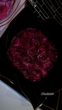 a black plate topped with pink flowers on top of a table