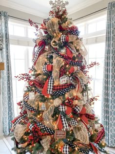 a christmas tree decorated with red, white and black ribbons