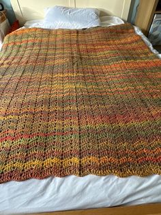 a crocheted blanket on top of a bed