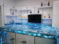 a kitchen counter made out of glass with blue swirls on it