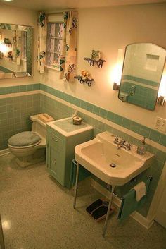 a bathroom with a toilet, sink and mirror