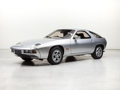 a silver sports car parked in a white room