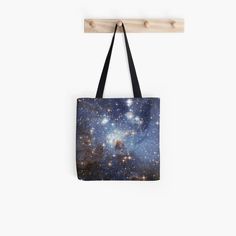 a tote bag hanging on a wall with stars in the sky and blue background