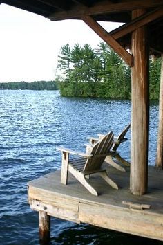 an empty chair sitting on the end of a dock