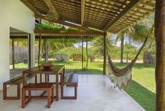 an outdoor dining area with hammock chairs and table