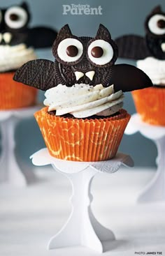 cupcakes decorated with chocolate and white frosting are displayed in the shape of bats