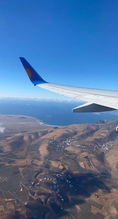 the wing of an airplane flying over land and water