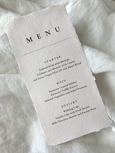 a menu card is laying on top of a white sheet with the word, menu