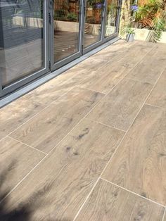 an outdoor patio with wood flooring and sliding glass doors