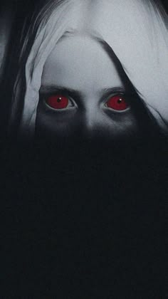 a woman's face with red eyes in the dark