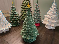 small ceramic christmas trees sitting on top of a wooden table