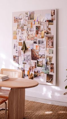 a table and chairs in front of a wall with pictures on it