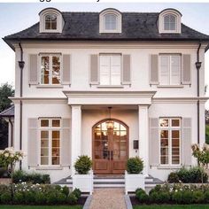 a large white house with two story windows and shutters on the front door is shown