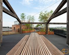 a wooden bench sitting on top of a hard wood floor next to a tall building