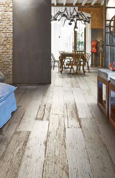 an image of a wood floor in a living room or dining room with exposed brick walls