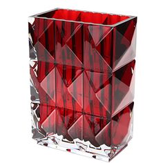 a red glass vase with many small squares on it's sides and one large square in the middle