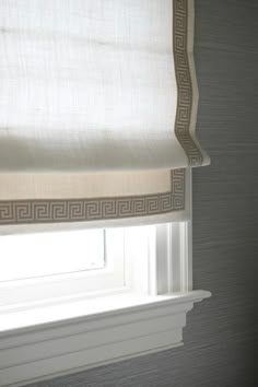 a window with roman blinds in the corner