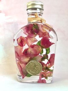 a bottle filled with pink flowers on top of a table