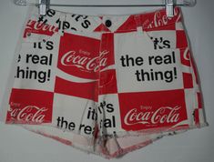 "Here's a pair of Coca-Cola red and white shorts cutoff jean shorts you'll adore. These cute and shortie cut off shorts (made that way) have a button closure at the waist with a zipper fly and front and back riveted pockets with the classic \"It's the real thing!\" slogan graphic print all over. Too cool! They have a low to mid rise waist and a great sturdy cotton denim material. These retro red shorts are in excellent condition with hardly any signs of wear/use and definitely no major stains/tears/flaws. The label says they are a tiny size S and flat measurements are here to check personal fit. Check out the photos and get these standout summer wardrobe staple keeper pair of vintage cutoff jean shorts! -- measurements taken laid flat, please double for circumference in inches --     Waist Retro White Short Bottoms, Red Graphic Print Shorts For Summer, Red Graphic Print Summer Shorts, Vintage High Waist White Shorts, Retro White Shorts For Spring, Vintage White Jean Shorts For Spring, White Retro Shorts For Spring, Vintage White Jean Shorts, Vintage White Cotton Jean Shorts