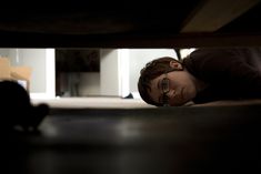 a woman laying on the ground with her head under a table