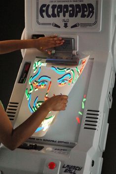 a woman is playing an old school video game with neon lights on her face and hands