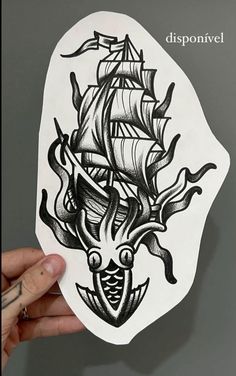 a hand holding up a sticker with a ship on it